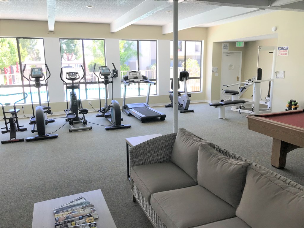 a gym with exercise equipment and a couch