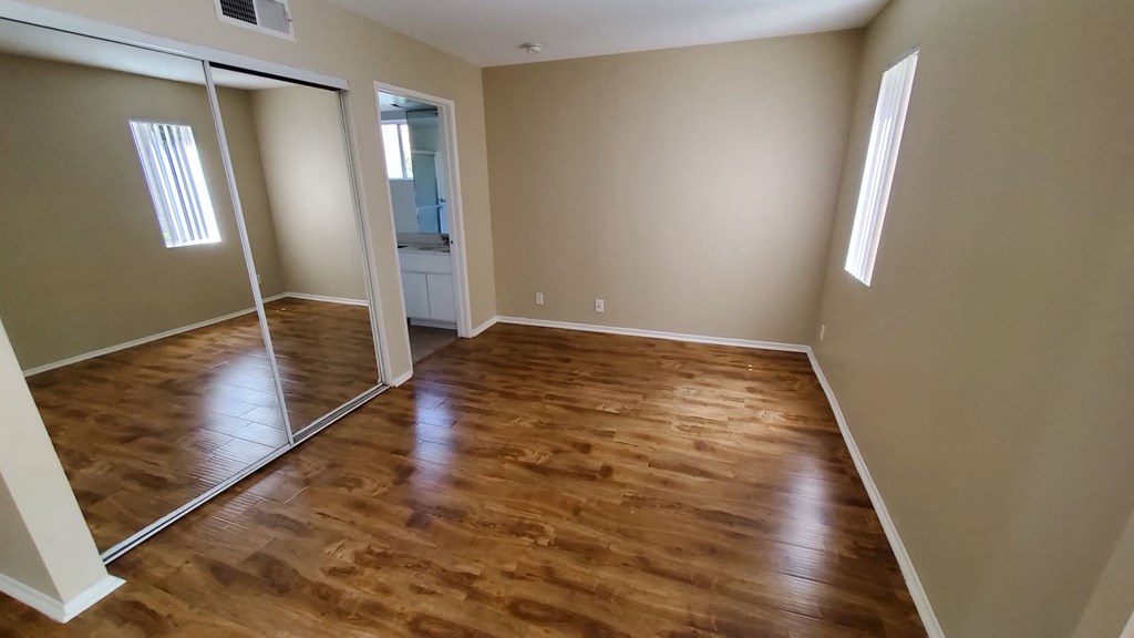 A room with wooden flooring and a sliding door.