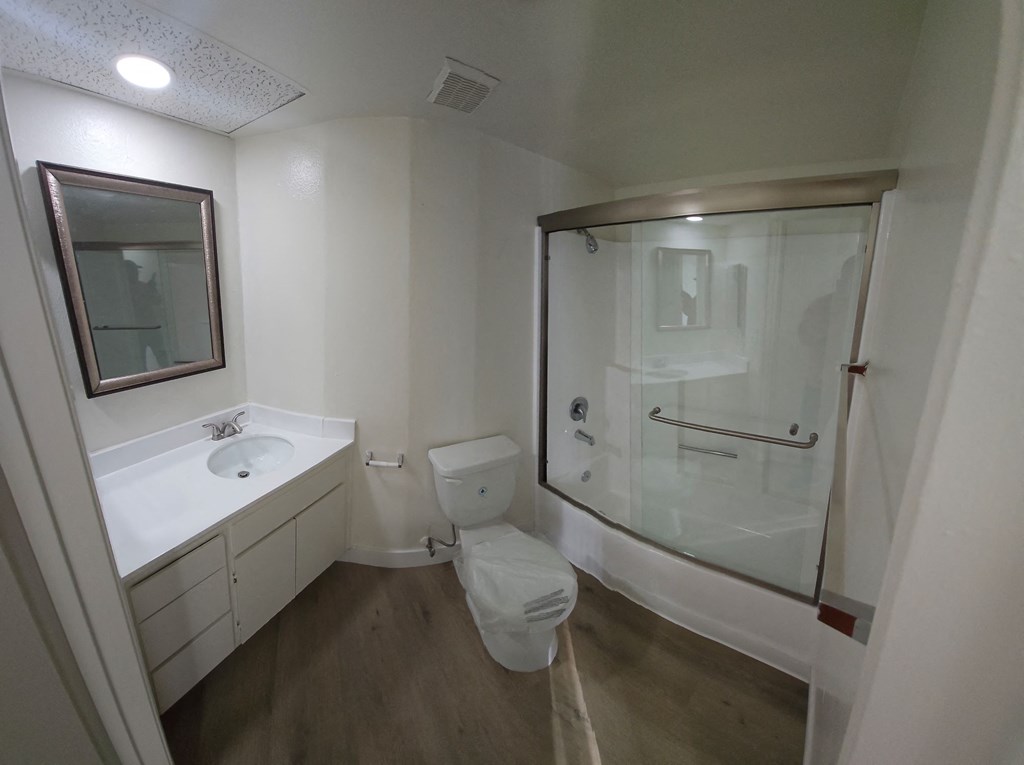 A white bathroom with a toilet, sink, and shower.