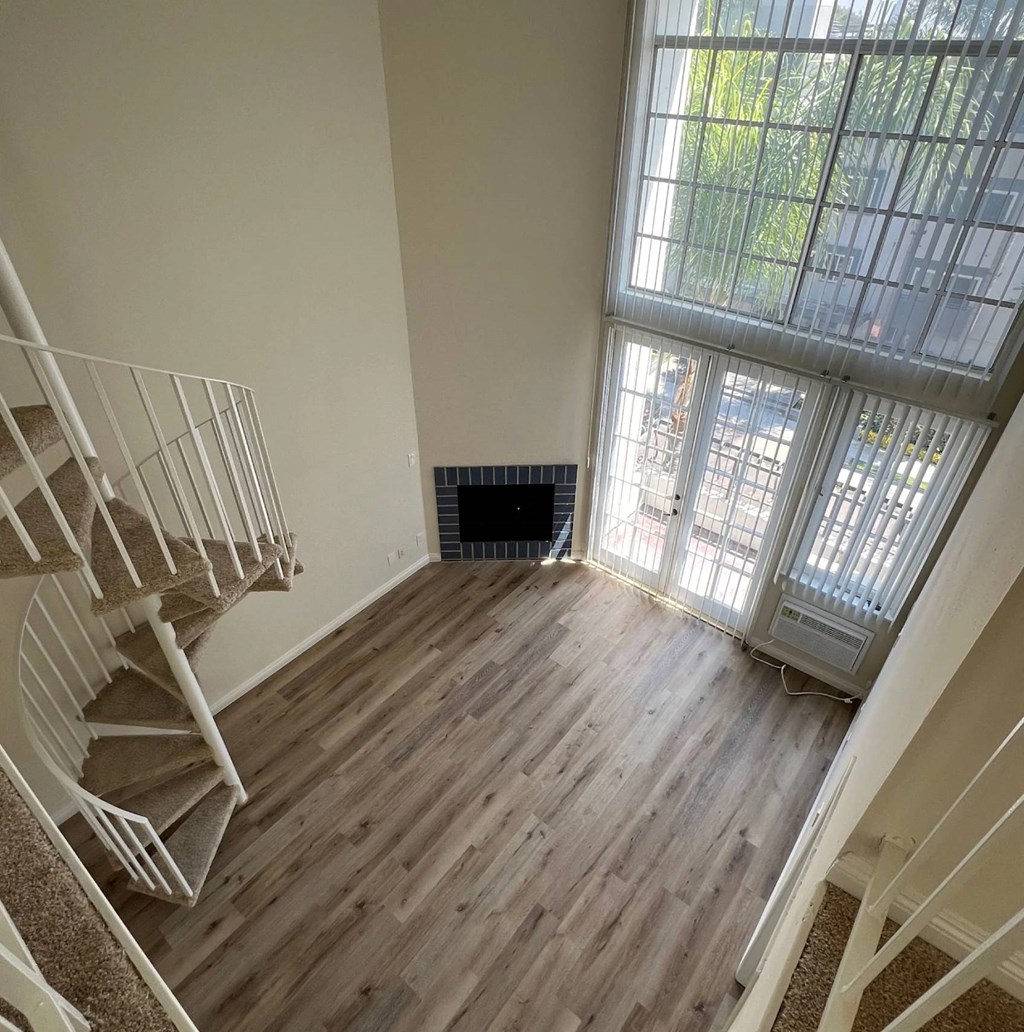 A room with a spiral staircase and a fireplace.