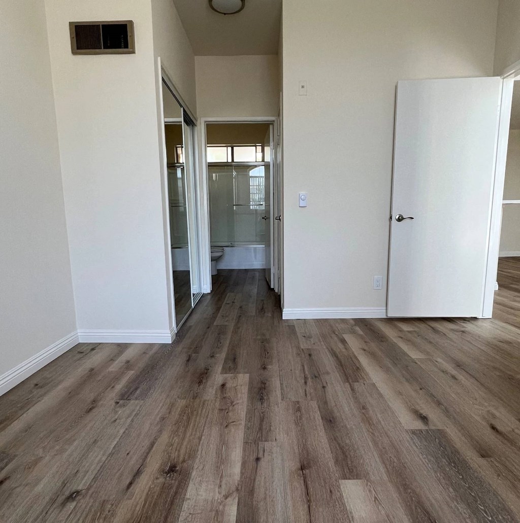 A room with wooden flooring and white walls.