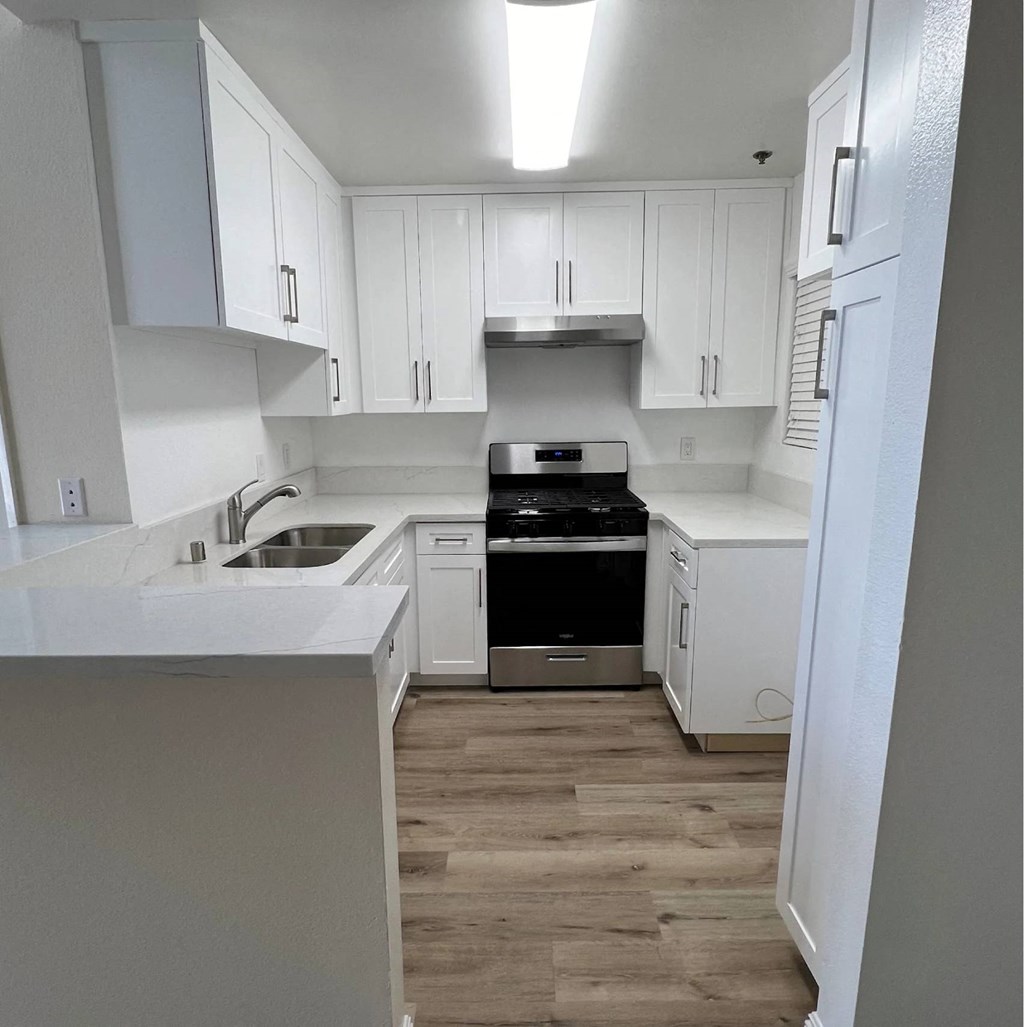 A kitchen with white cabinets and a black stove top oven.