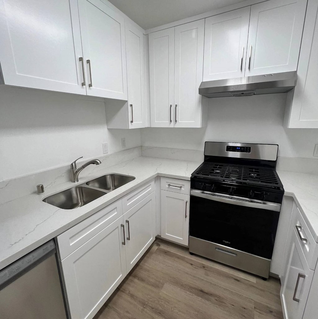 A kitchen with white cabinets and a black stove top oven.