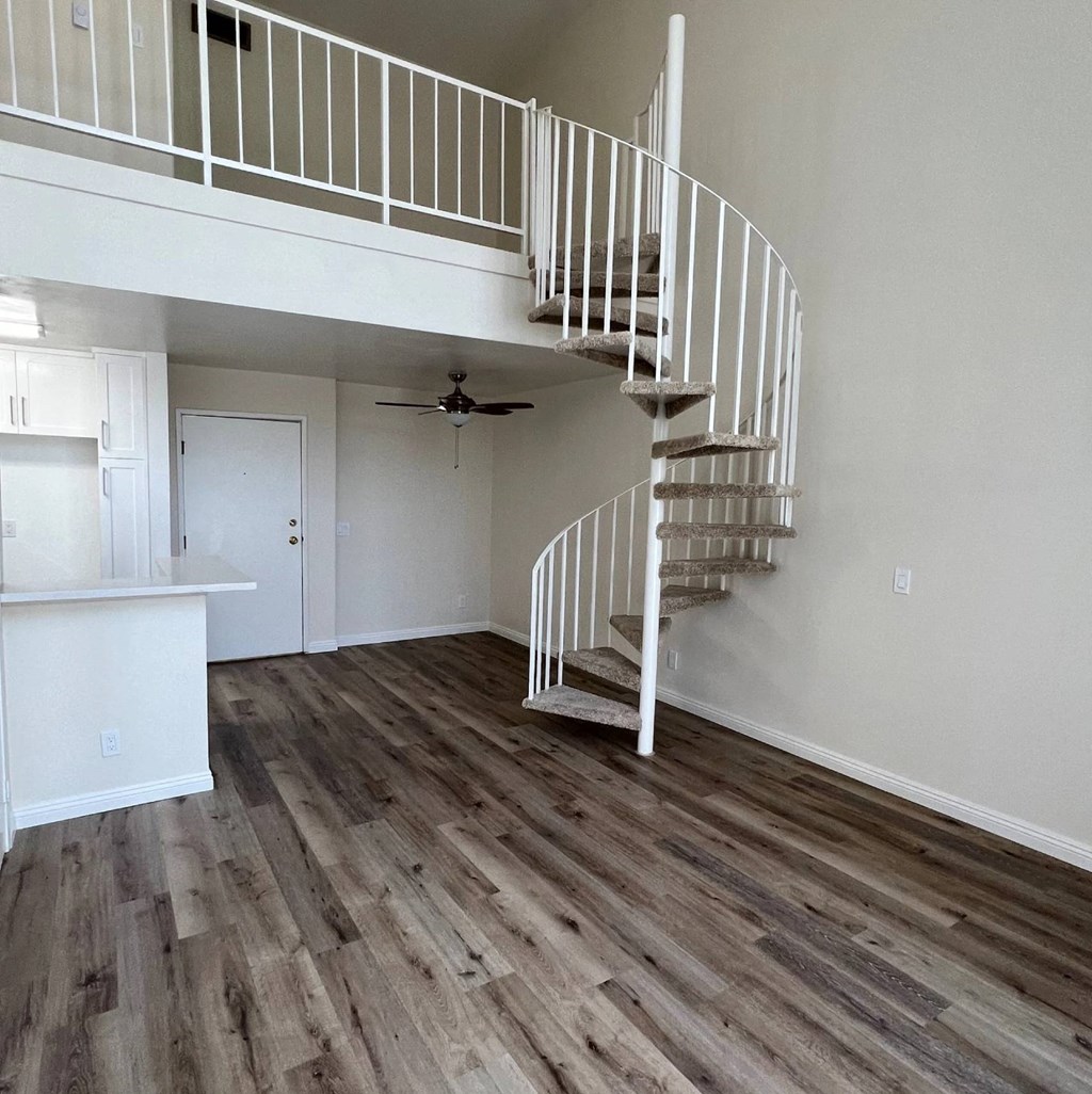 A spiral staircase in a room with wooden flooring.