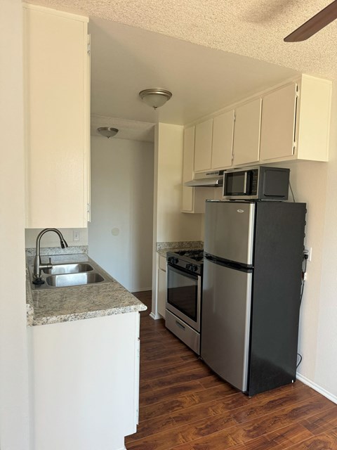 A kitchen with a black refrigerator and stove.
