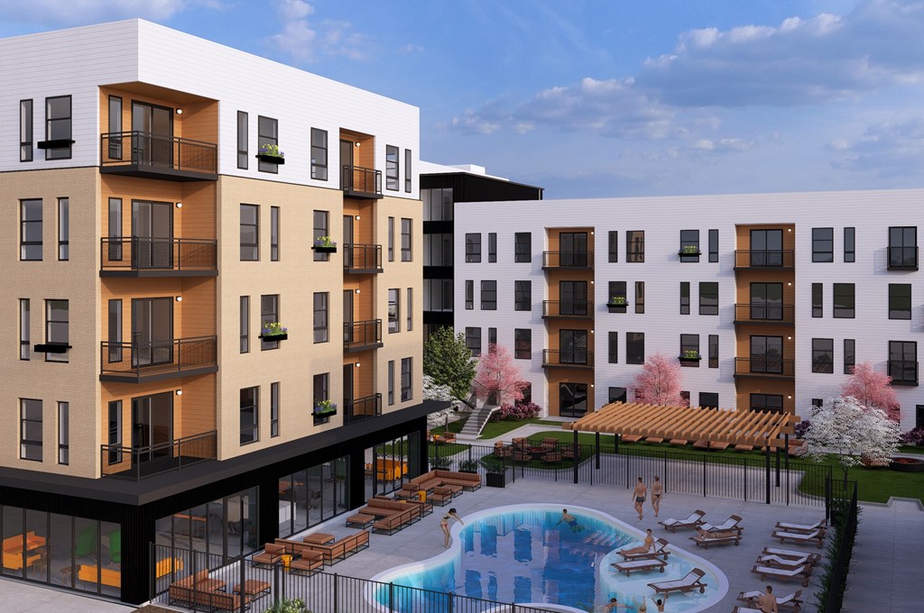 A modern apartment complex with a pool and outdoor seating area.