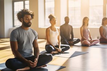 A group of people are sitting in a yoga class.
