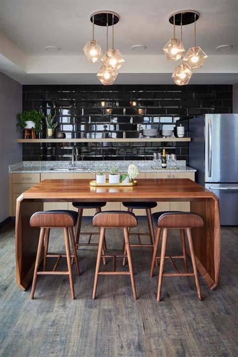 a kitchen with a wooden table and bar stools