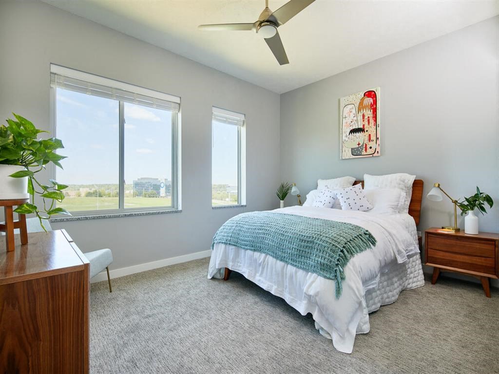 a bedroom with a bed and three windows