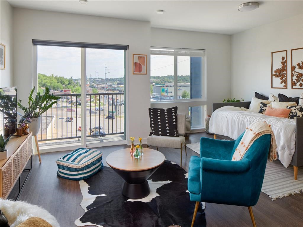a living room with a bed and a balcony