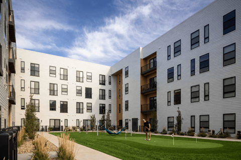 A modern apartment complex with a playground in the front.