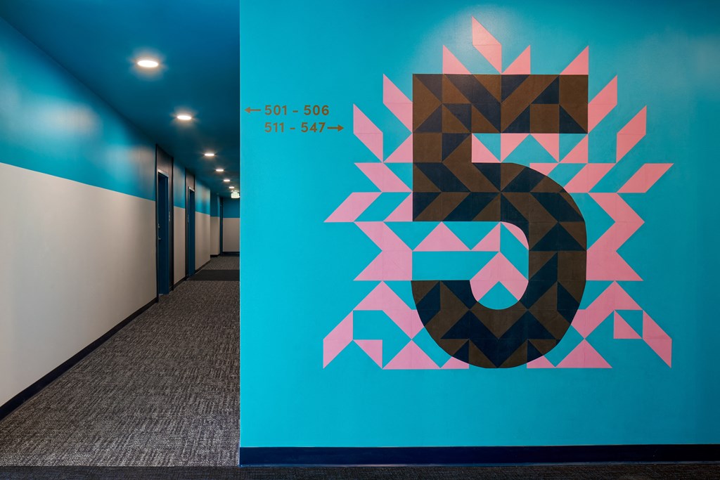 a blue wall with a geometric design on it in a hallway