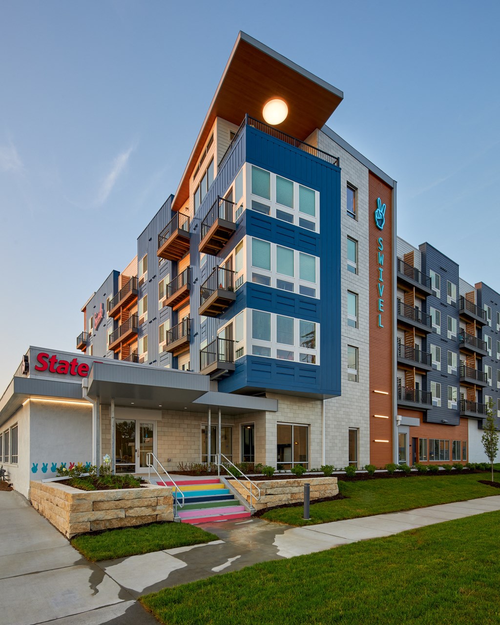 a large apartment building with colorful stairs in front of it