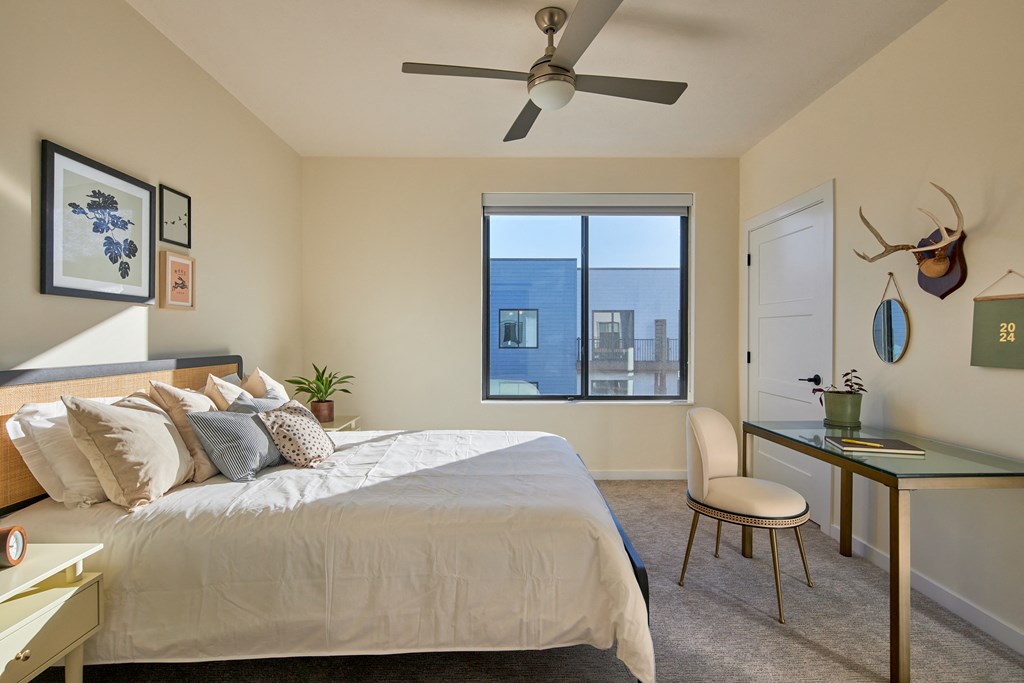 a bedroom with a large bed and a ceiling fan