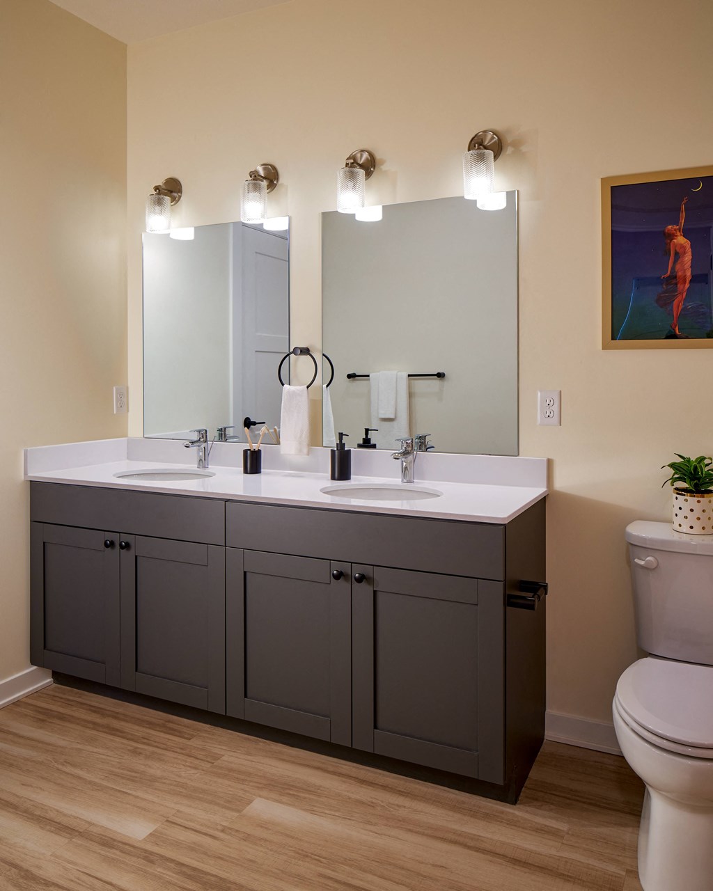 a bathroom with a sink and two mirrors and a toilet