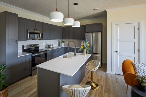 a kitchen with gray cabinets and a white counter top