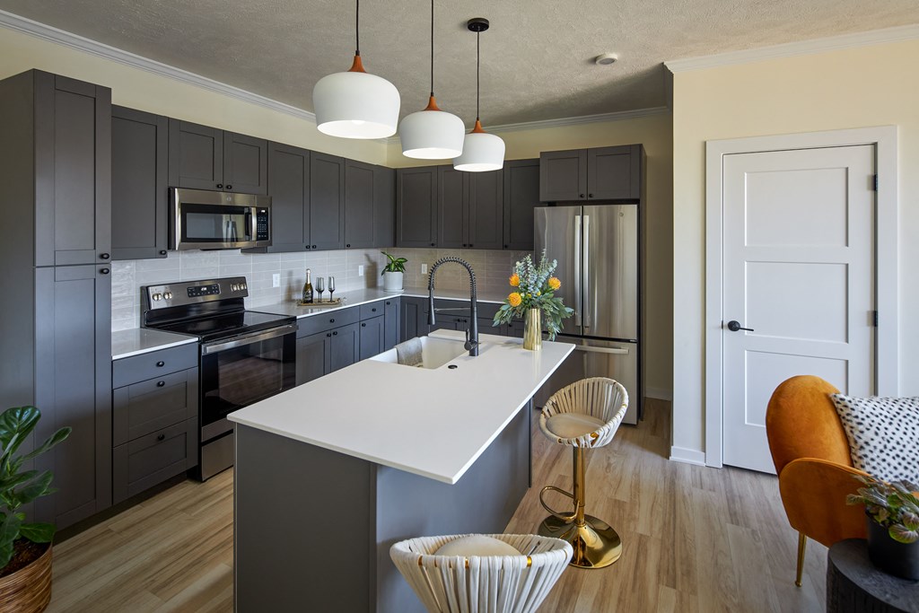 a kitchen with gray cabinets and a white counter top