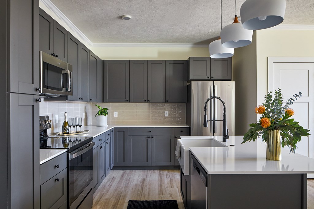 a kitchen with gray cabinets and a white counter top