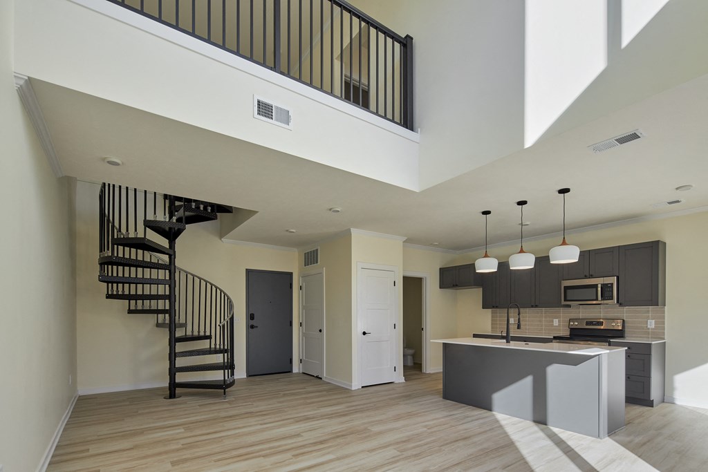 an open kitchen and living room with a spiral staircase