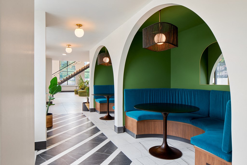 a lobby with blue and green seating and a table