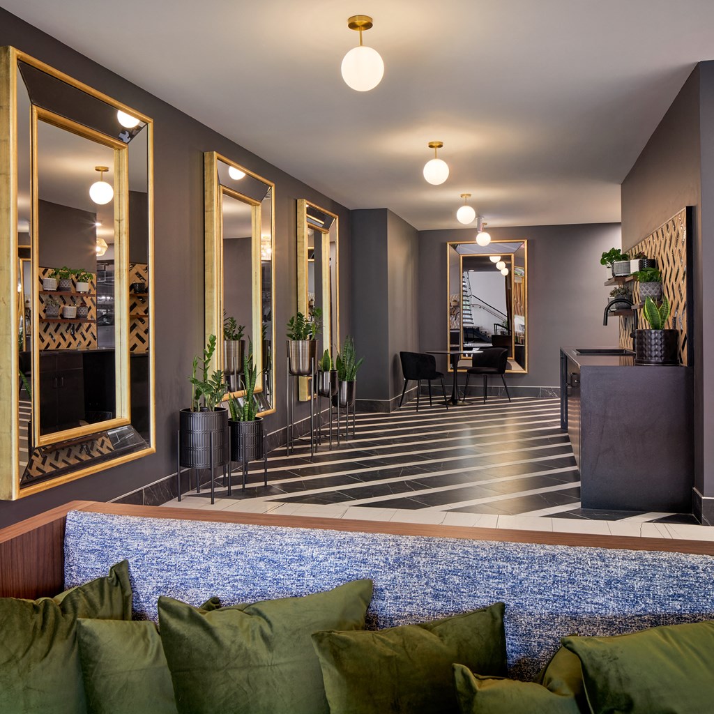 a living room with a blue rug and a lobby with mirrors