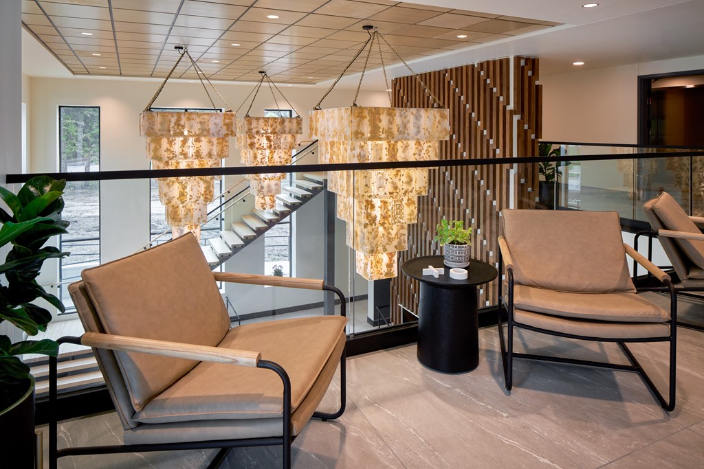 the lobby of a hotel with chairs and chandeliers