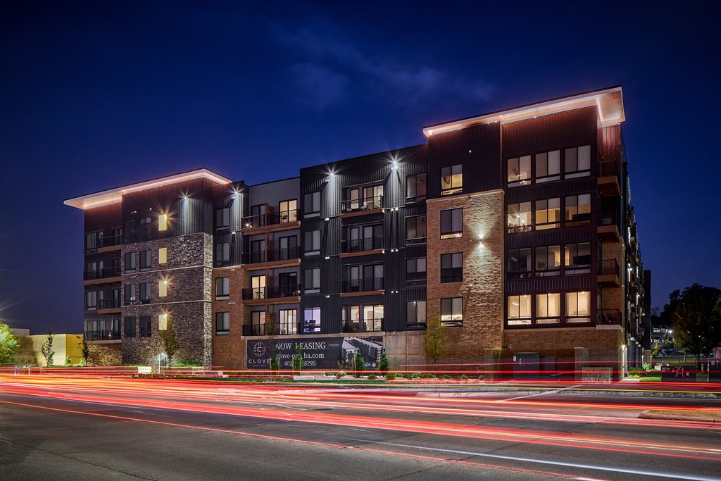 A modern building with a sign that says "Now Yon Kwang" is lit up at night.