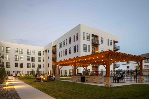 A modern building with a white facade and a wooden pergola in front.