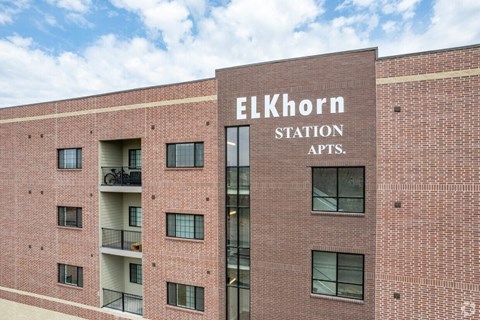 A red brick building with the words "Elkhorn Station Apts." on the front.