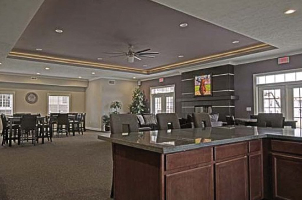 A large room with a counter and chairs.