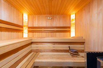 a wooden sauna with a bucket on the floor