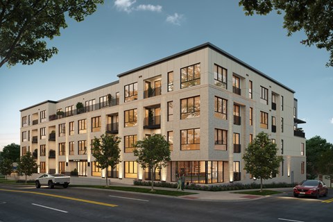 A modern apartment building with cars parked in front.