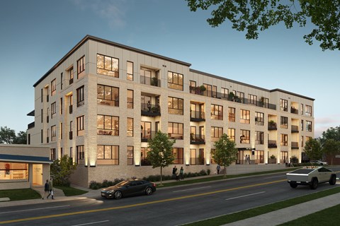 A modern apartment building with cars parked in front.
