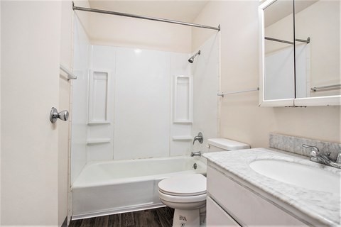 A white bathroom with a toilet, sink, and bathtub.