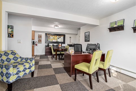 A room with a checkered floor and a couch with a yellow and blue patterned cover.