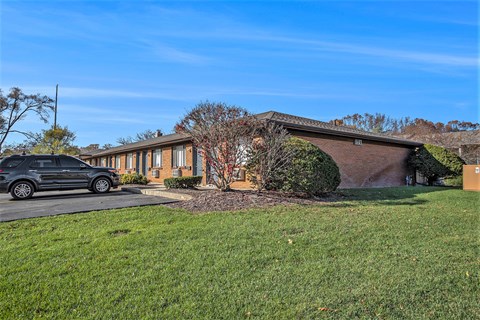 A house with a grey car parked in front.