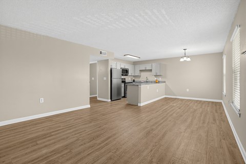 A kitchen area with a refrigerator, microwave, and cabinets.