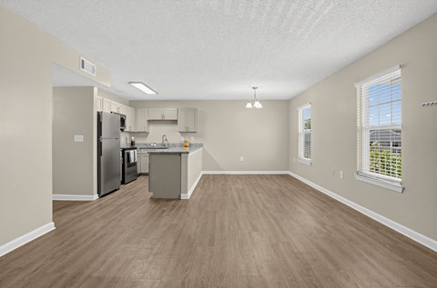 A kitchen with a refrigerator, microwave, and oven.