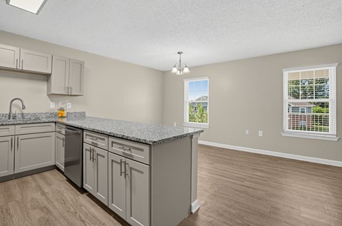A kitchen with a large island and wooden floors.
