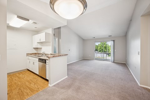 A spacious kitchen with white cabinets and a granite countertop.