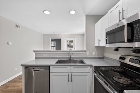 A modern kitchen with a stainless steel dishwasher and oven.