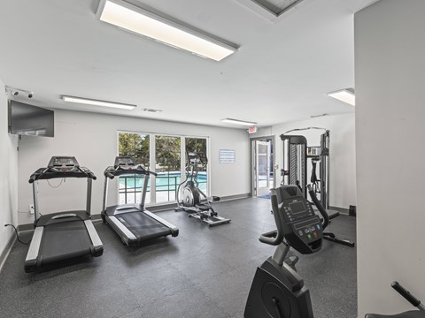 A gym with treadmills, exercise bikes, and other equipment.