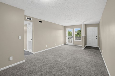 Spacious foyer and living room with carpeted floor and white walls at Arbours at Victoria Place in Prattville, AL