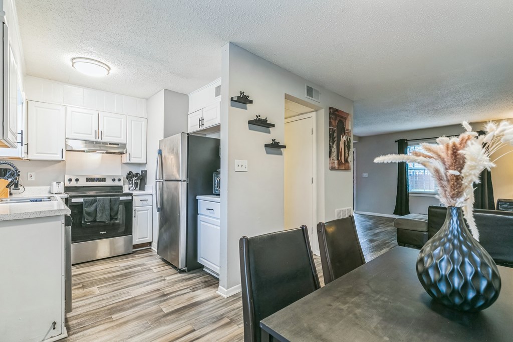 A kitchen with a refrigerator, oven, and sink.