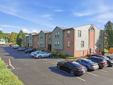 A parking lot with cars and apartment buildings in the background.