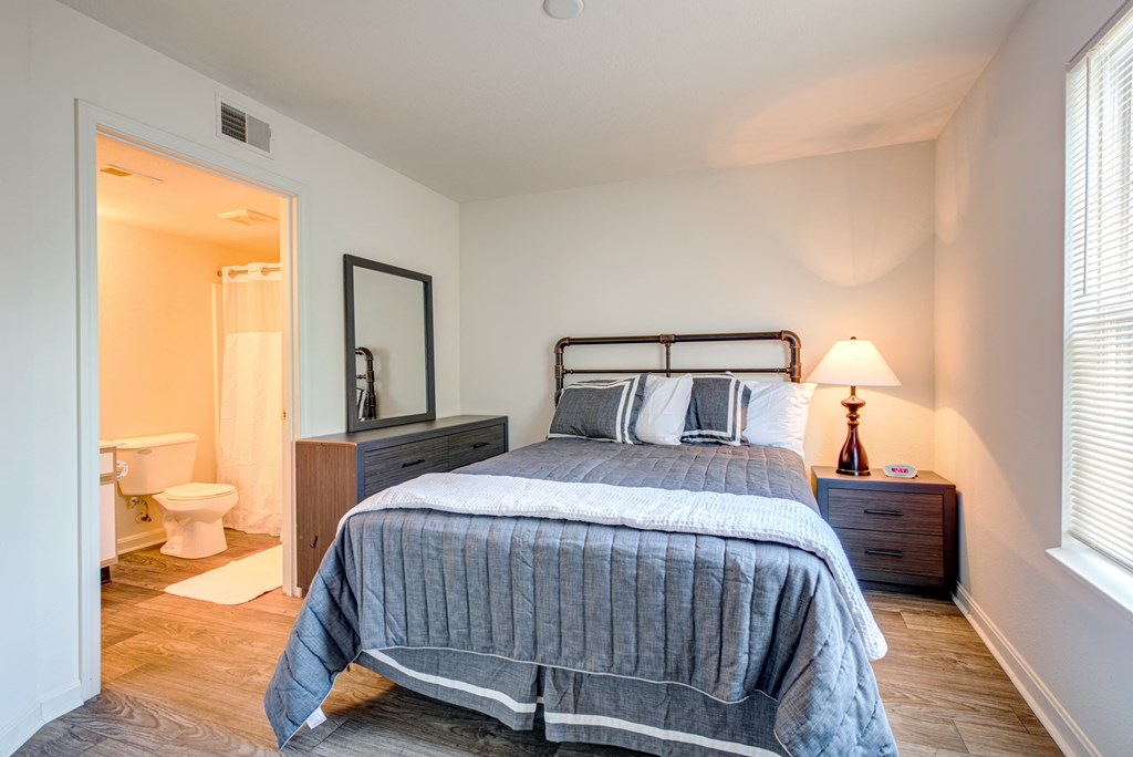 a bedroom with a bed and a bathroom with a toilet