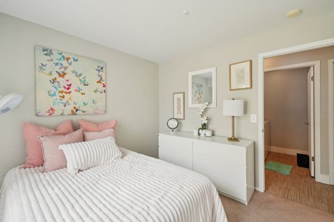 A bedroom with a large bed and a painting on the wall.