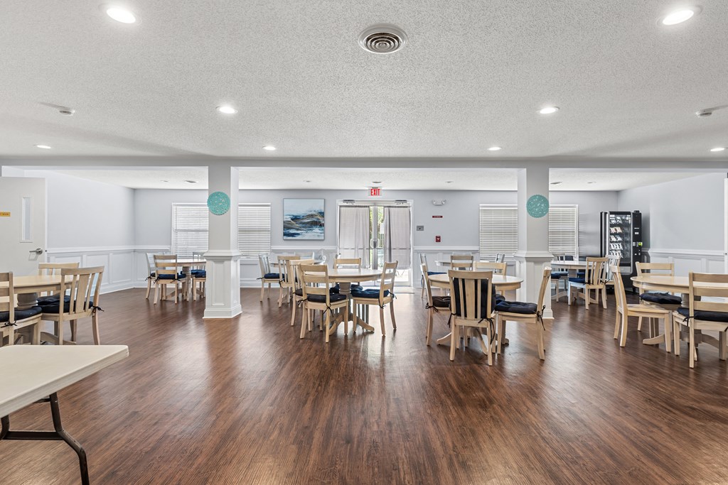a large dining room with tables and chairs and a hard wood floor