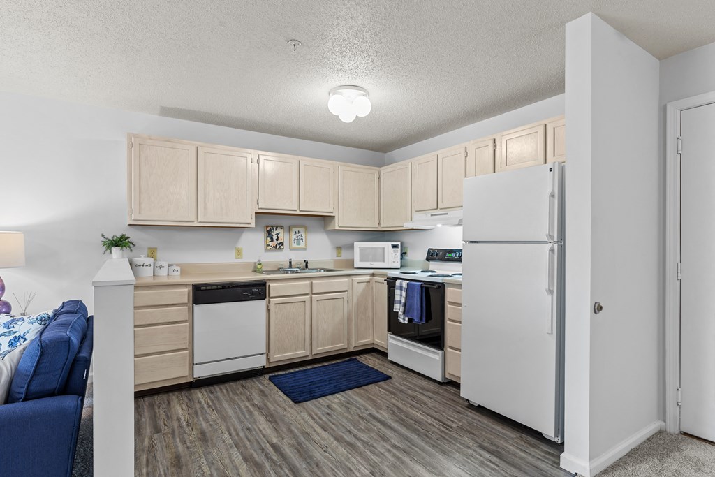 a kitchen with white appliances and wooden cabinets and a white refrigerator