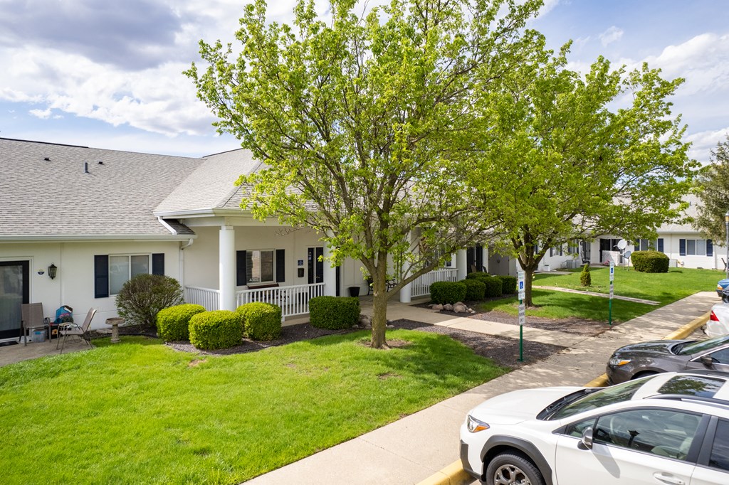 the view of a white building with cars parked in front of it